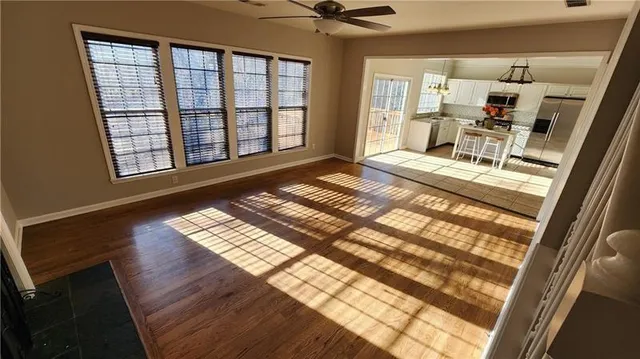 a view of a hall with wooden floor and a rug