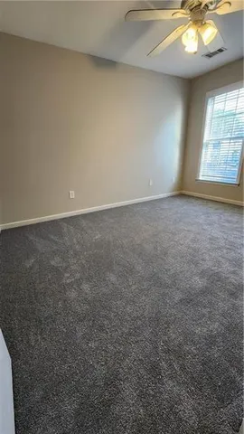 an empty room with a chandelier fan