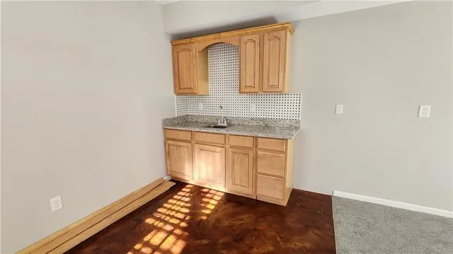 an empty room with chandelier fan and windows