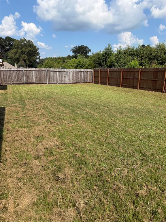 520 Big Red Circle Haughton, LA 71037 - Photo 25 of 25 Expansive backyard featuring a large grassy area, a perimeter of wood fencing, and mature trees beyond the fence line