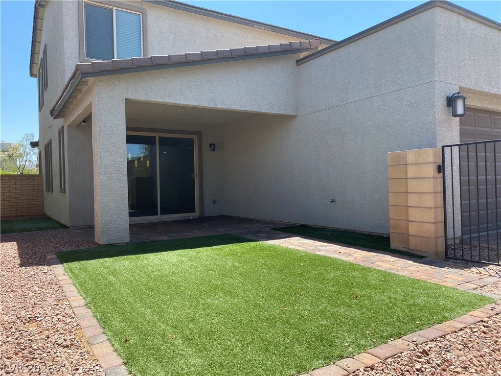 436 Cadence View Way Henderson, NV 89011 - Photo 33 of 36 A private outdoor space with artificial turf and a covered patio for relaxed entertaining.