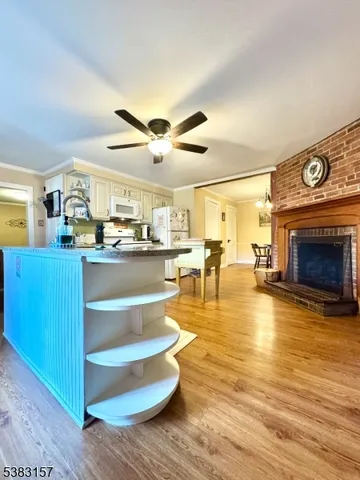 a living room with stainless steel appliances kitchen island granite countertop furniture and a fireplace