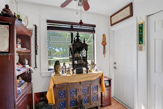 a table that has painting on the wall and a large window