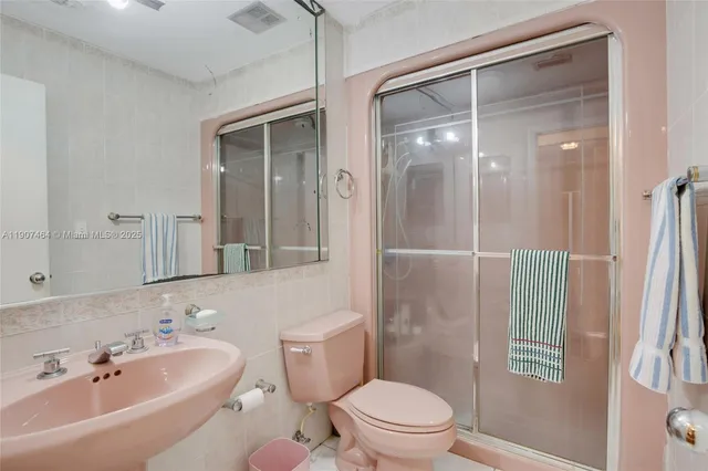 a bathroom with a bathtub shower sink mirror and toilet