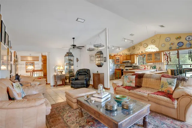 a living room with furniture kitchen view and a large window