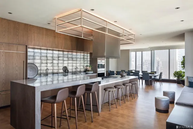 a kitchen with lots of counter and chairs