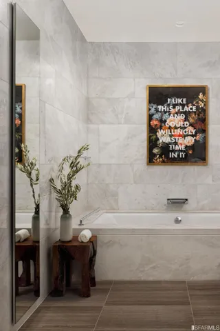 a bathroom with a bathtub and a potted plant