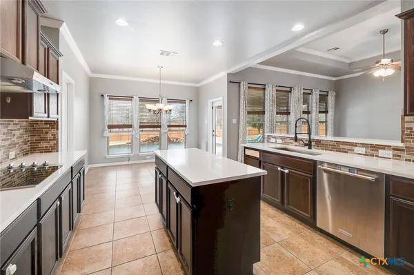 a kitchen with a stove sink and cabinets