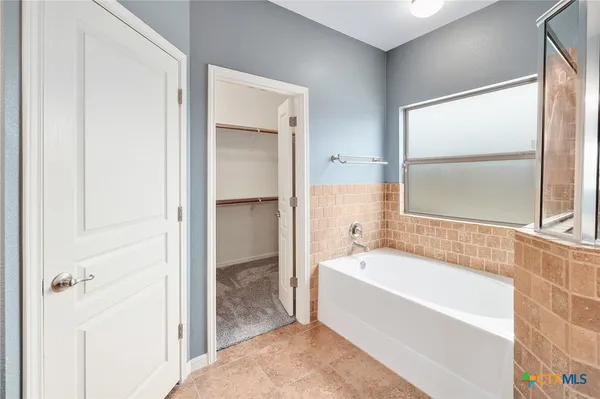 a spacious bathroom with a bathtub and a shower