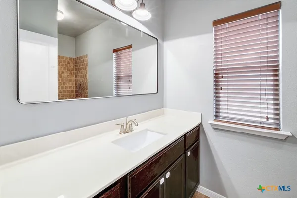a bathroom with a sink a vanity and a mirror