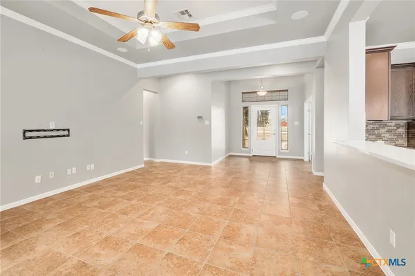 a view of an empty room with window and wooden floor