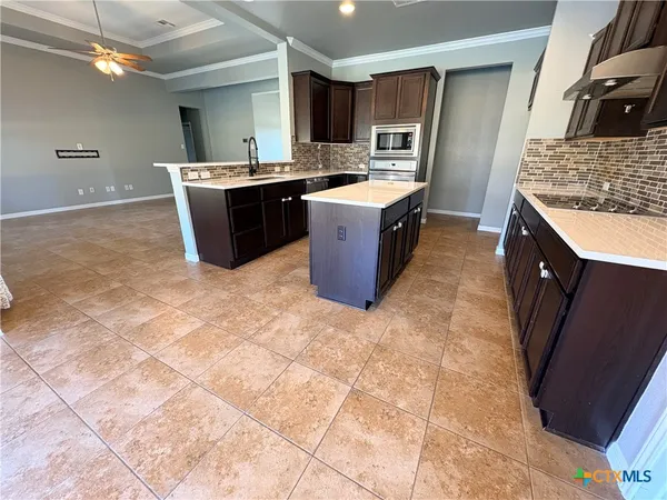 a large kitchen with a stove a sink dishwasher and a refrigerator