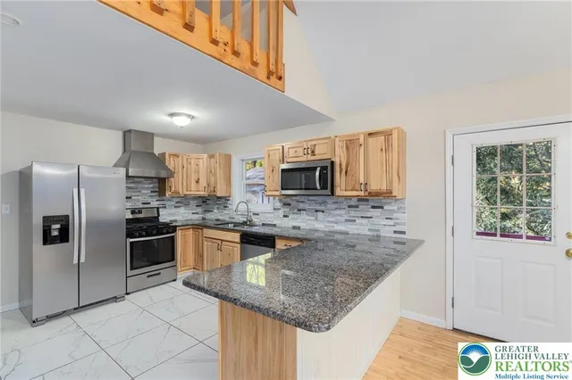 a kitchen with stainless steel appliances granite countertop a sink stove and refrigerator