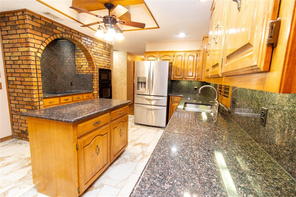 3014 Pecan Ridge Drive Rowlett, TX 75088 - Photo 5 of 29 a kitchen with stainless steel appliances granite countertop a sink and a refrigerator