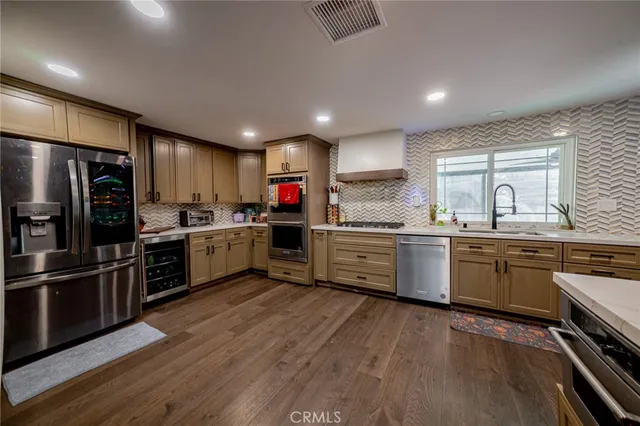 a kitchen with a refrigerator cabinets stainless steel appliances and a window