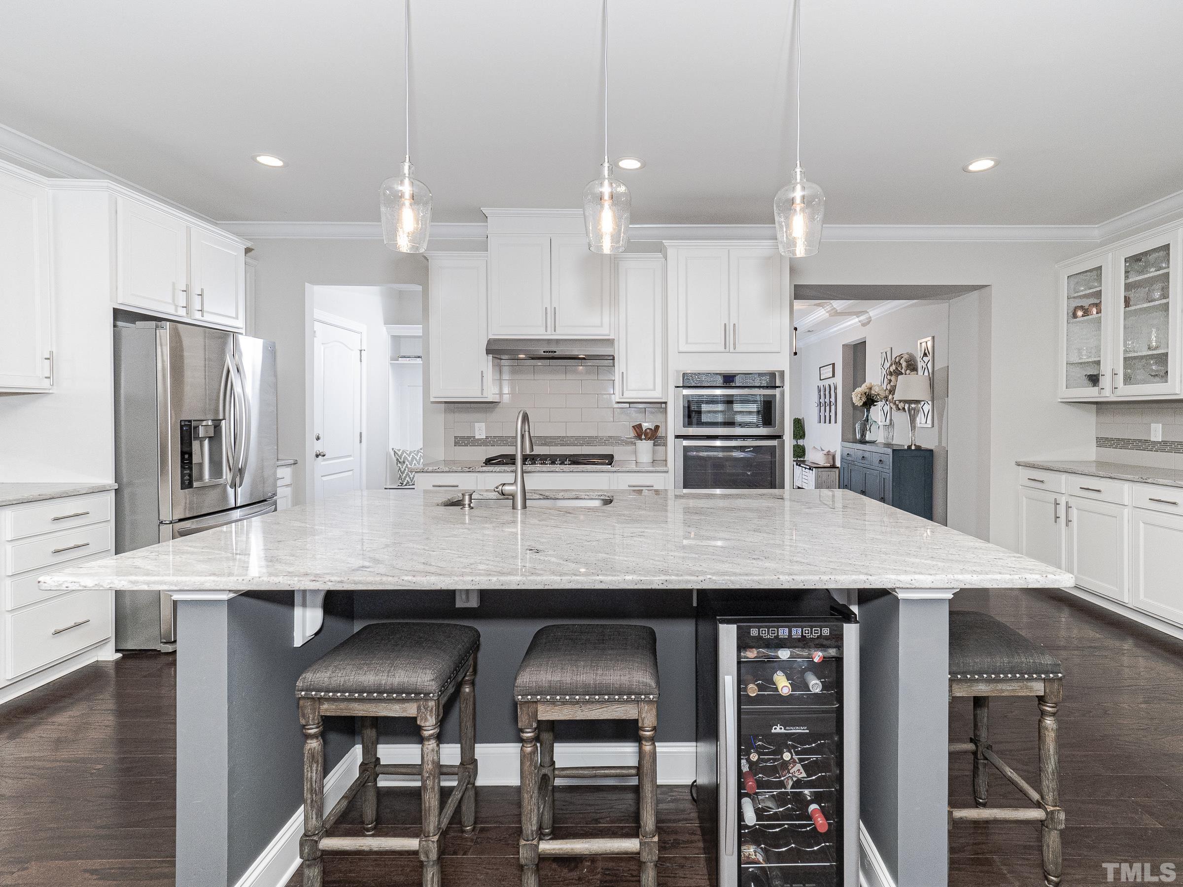 1303 Capstone Drive Durham, NC 27713 - Photo 13 of 27 a kitchen with stainless steel appliances granite countertop a kitchen island and chairs in it