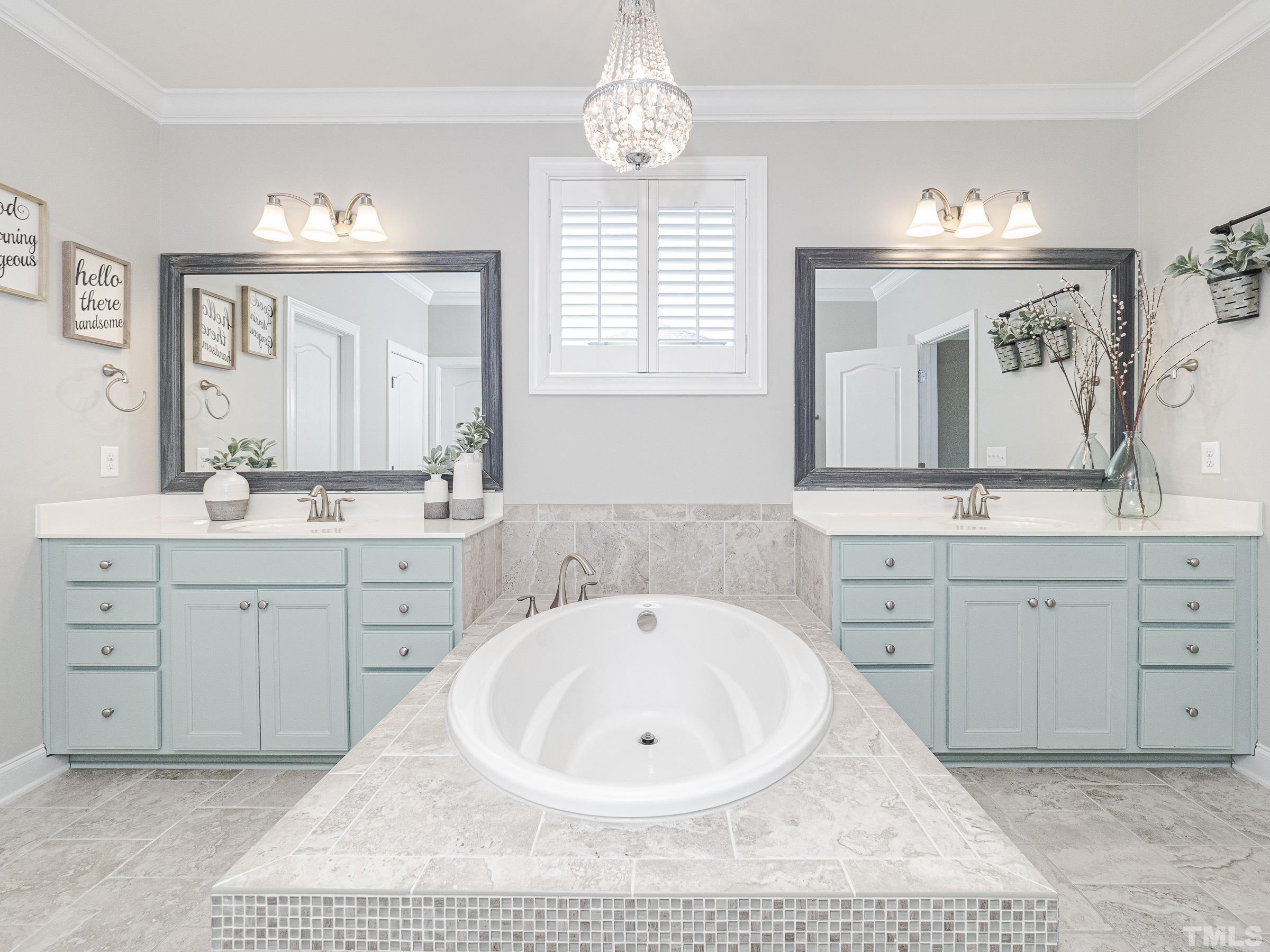 1303 Capstone Drive Durham, NC 27713 - Photo 23 of 27 a spacious bathroom with a double vanity sink mirror and a bathtub