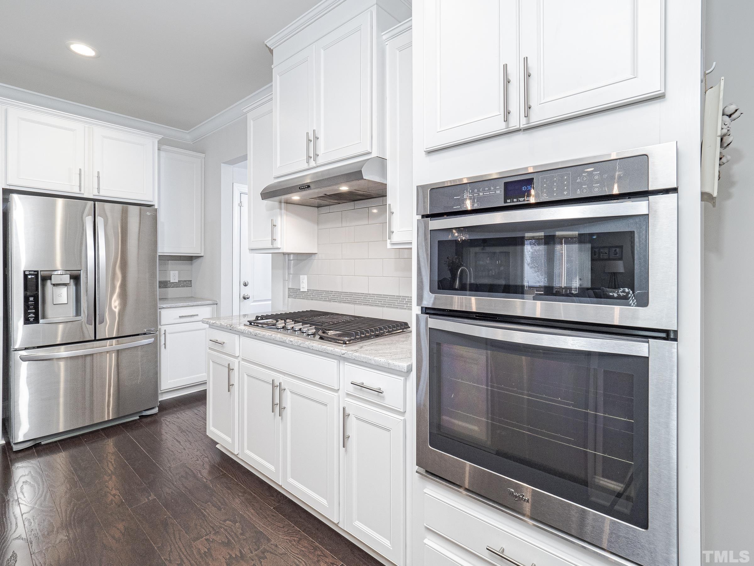 1303 Capstone Drive Durham, NC 27713 - Photo 10 of 27 a kitchen with stainless steel appliances white cabinets and a stove