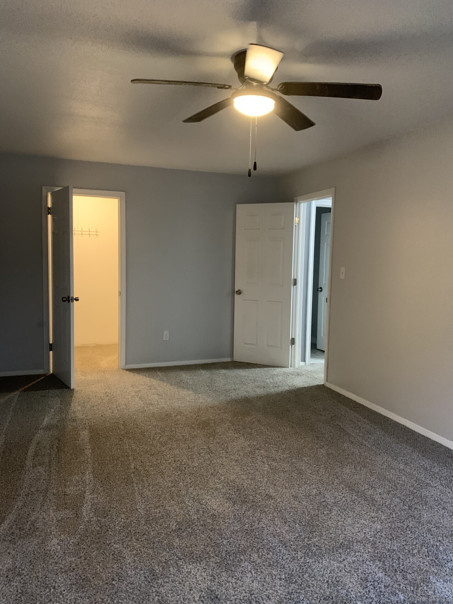 507 Emmett Street, Unit 13 Bristol, CT 06010 - Photo 10 of 16 an empty room with a chandelier fan and windows