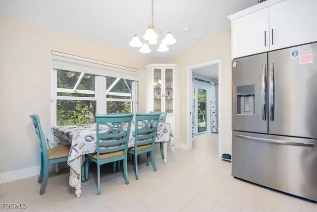 a dining room with furniture a chandelier and window
