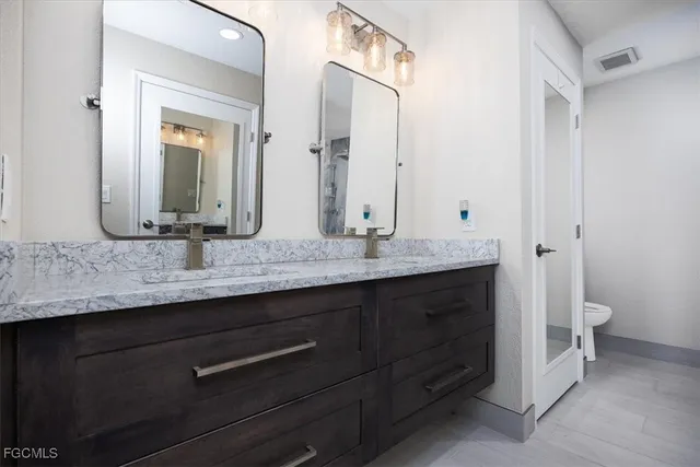 a bathroom with a granite countertop sink and a mirror