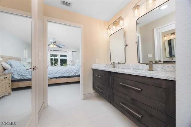 a en suite bathroom with a double vanity sink and a mirror