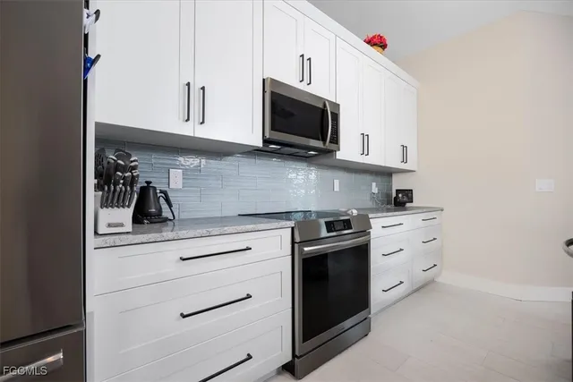 a kitchen with white cabinets stainless steel appliances and sink