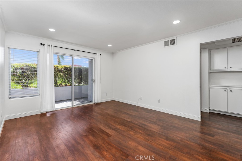 34264 Camino Capistrano, Unit 102 Dana Point, CA 92624 - Photo 11 of 37 a view of an empty room with wooden floor and a window