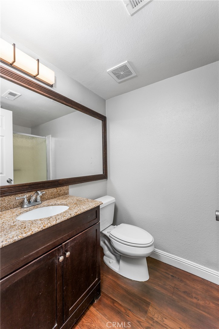 34264 Camino Capistrano, Unit 102 Dana Point, CA 92624 - Photo 17 of 37 a bathroom with a granite countertop sink a toilet and a mirror