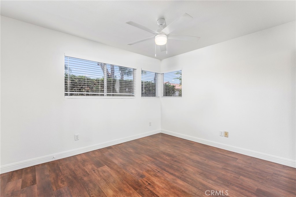 34264 Camino Capistrano, Unit 102 Dana Point, CA 92624 - Photo 20 of 37 a view of an empty room with wooden floor and a ceiling fan