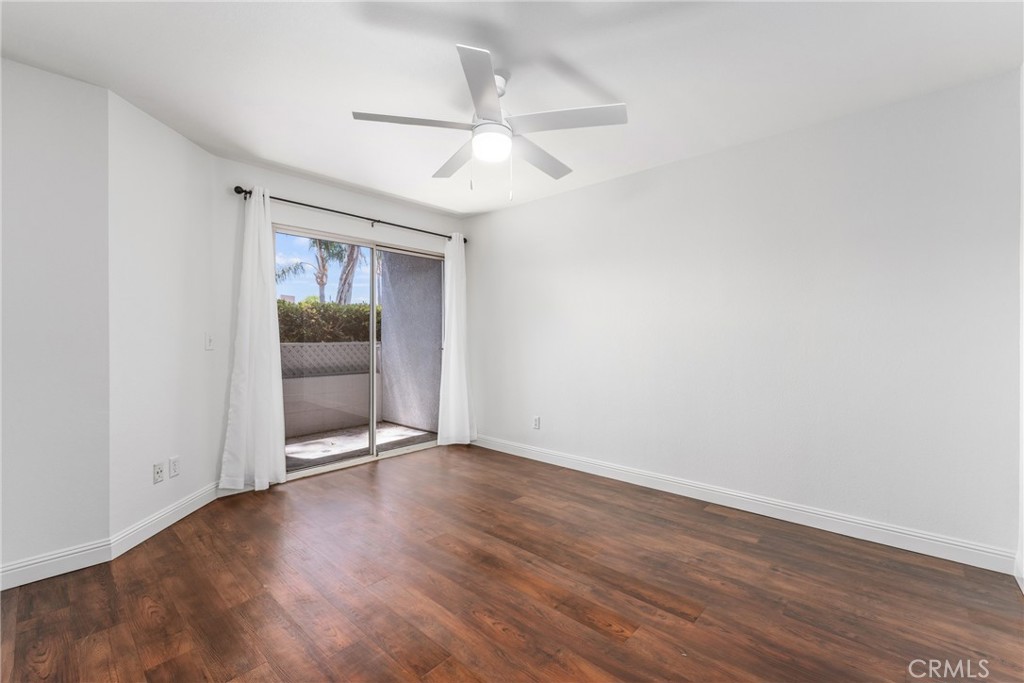 34264 Camino Capistrano, Unit 102 Dana Point, CA 92624 - Photo 22 of 37 a view of an empty room with a window and wooden floor