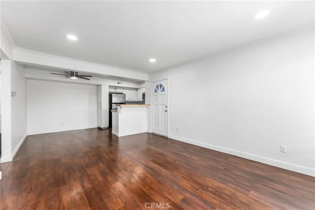 a view of empty room with wooden floor