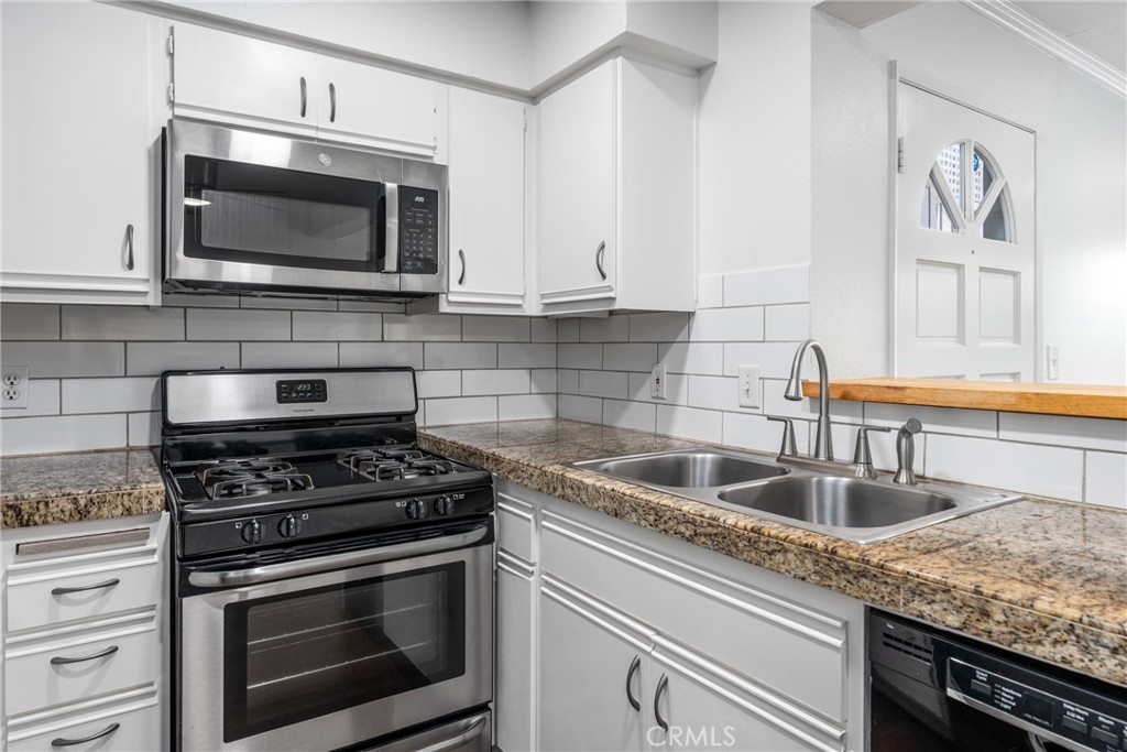 34264 Camino Capistrano, Unit 102 Dana Point, CA 92624 - Photo 7 of 37 a kitchen with granite countertop a stove and a microwave
