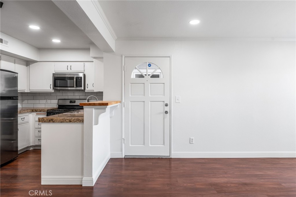34264 Camino Capistrano, Unit 102 Dana Point, CA 92624 - Photo 10 of 37 a kitchen with granite countertop a refrigerator and a stove top oven