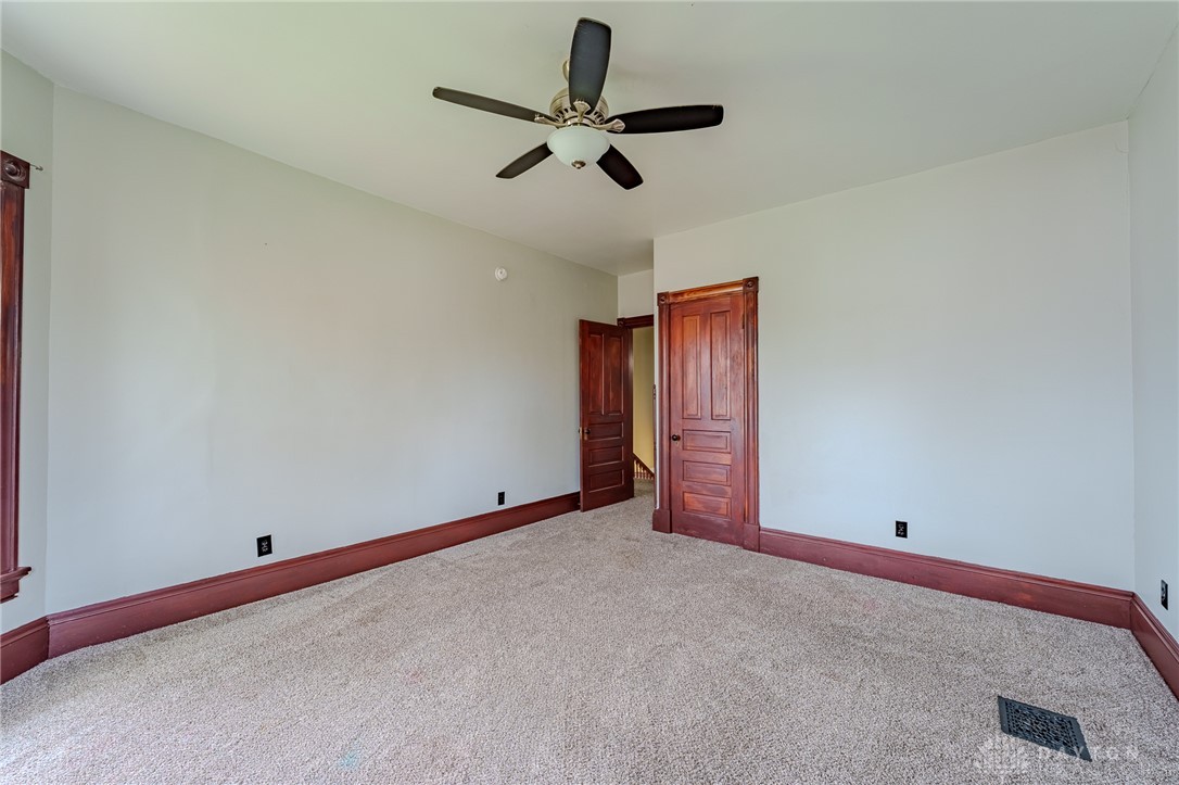 308 Yankee Road Middletown, OH 45044 - Photo 32 of 47 This airy bedroom features plush carpeting and classic wooden trim, offering a comfortable and inviting space.