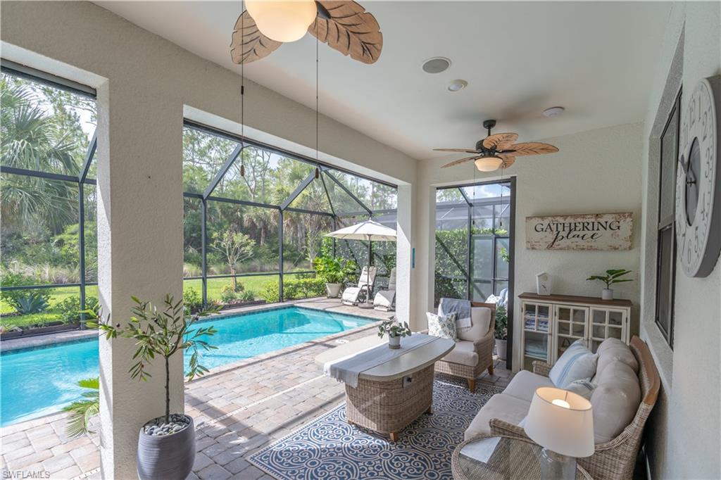 6848 Winding Cypress Drive Naples, FL 34114 - Photo 13 of 47 a living room with furniture and a floor to ceiling window