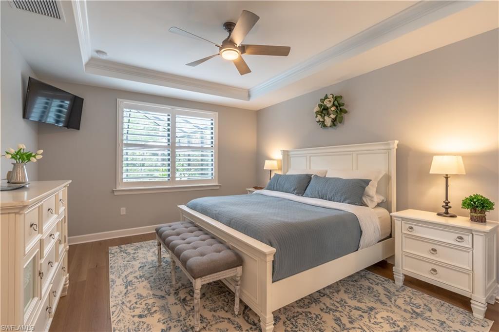 6848 Winding Cypress Drive Naples, FL 34114 - Photo 20 of 47 a bedroom with a bed and a chandelier