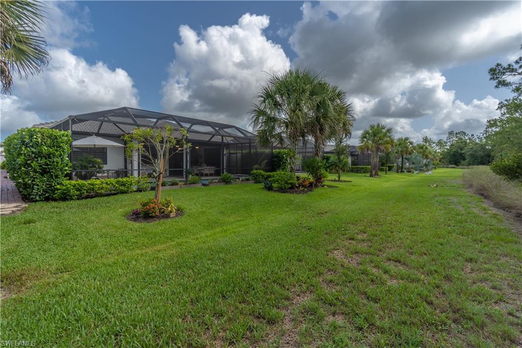 6848 Winding Cypress Drive Naples, FL 34114 - Photo 35 of 47 a view of a house with a backyard and a garden