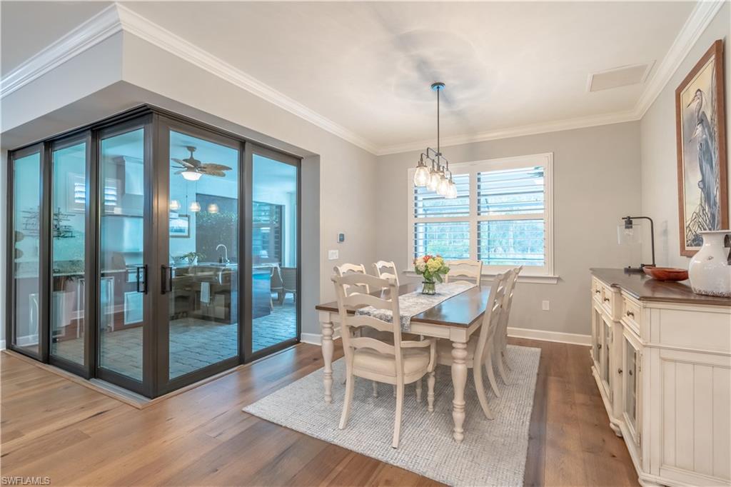 6848 Winding Cypress Drive Naples, FL 34114 - Photo 9 of 47 a dining room with furniture a chandelier and wooden floor