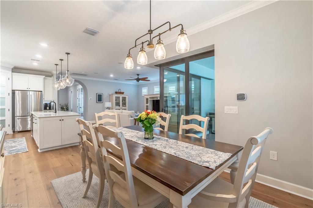 6848 Winding Cypress Drive Naples, FL 34114 - Photo 10 of 47 a view of a dining room with furniture and wooden floor