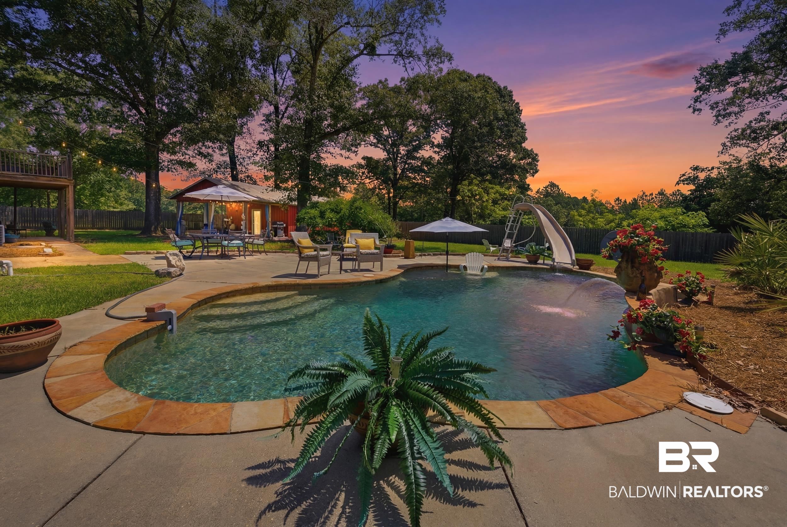 51620 Robert White Road Bay Minette, AL 36507 - Photo 2 of 81 Resort-style backyard featuring a freeform swimming pool with integrated steps, a concrete surround, and a stone coping