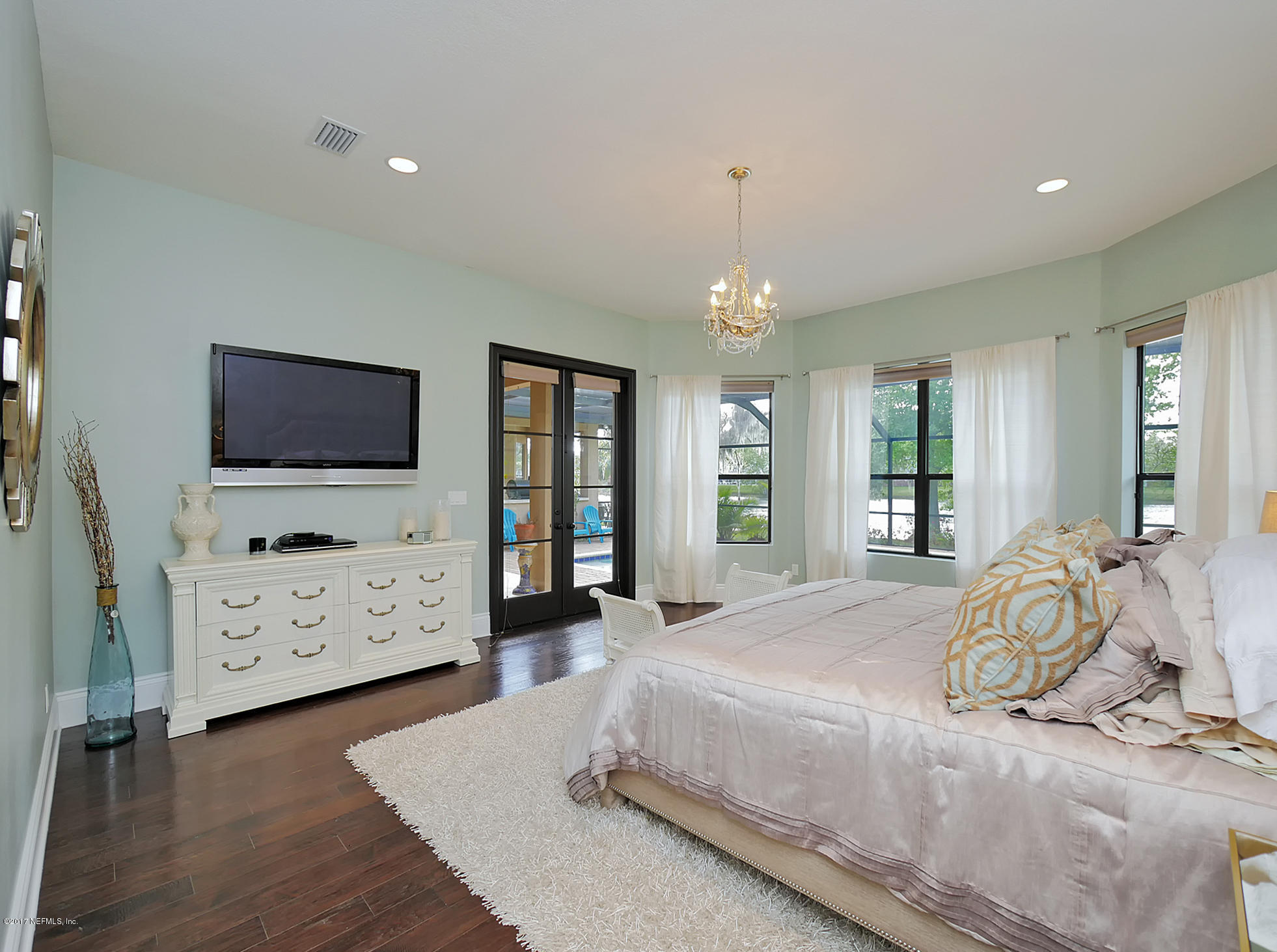 8074 Green Glade Road Jacksonville, FL 32256 - Photo 31 of 71 a spacious bedroom with a bed and a flat screen tv