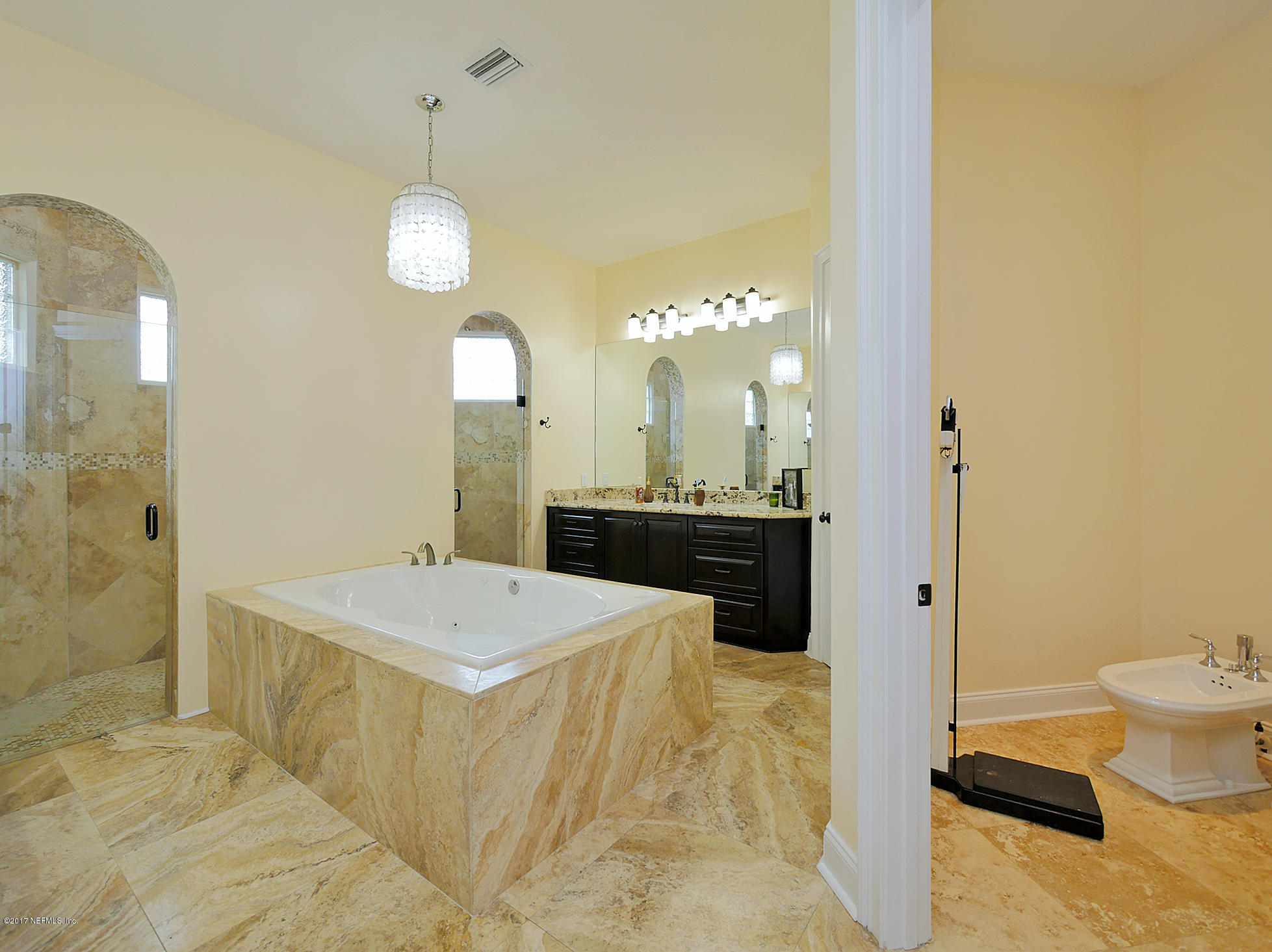 8074 Green Glade Road Jacksonville, FL 32256 - Photo 32 of 71 a large bathroom with a double vanity sink a toilet a mirror and shower