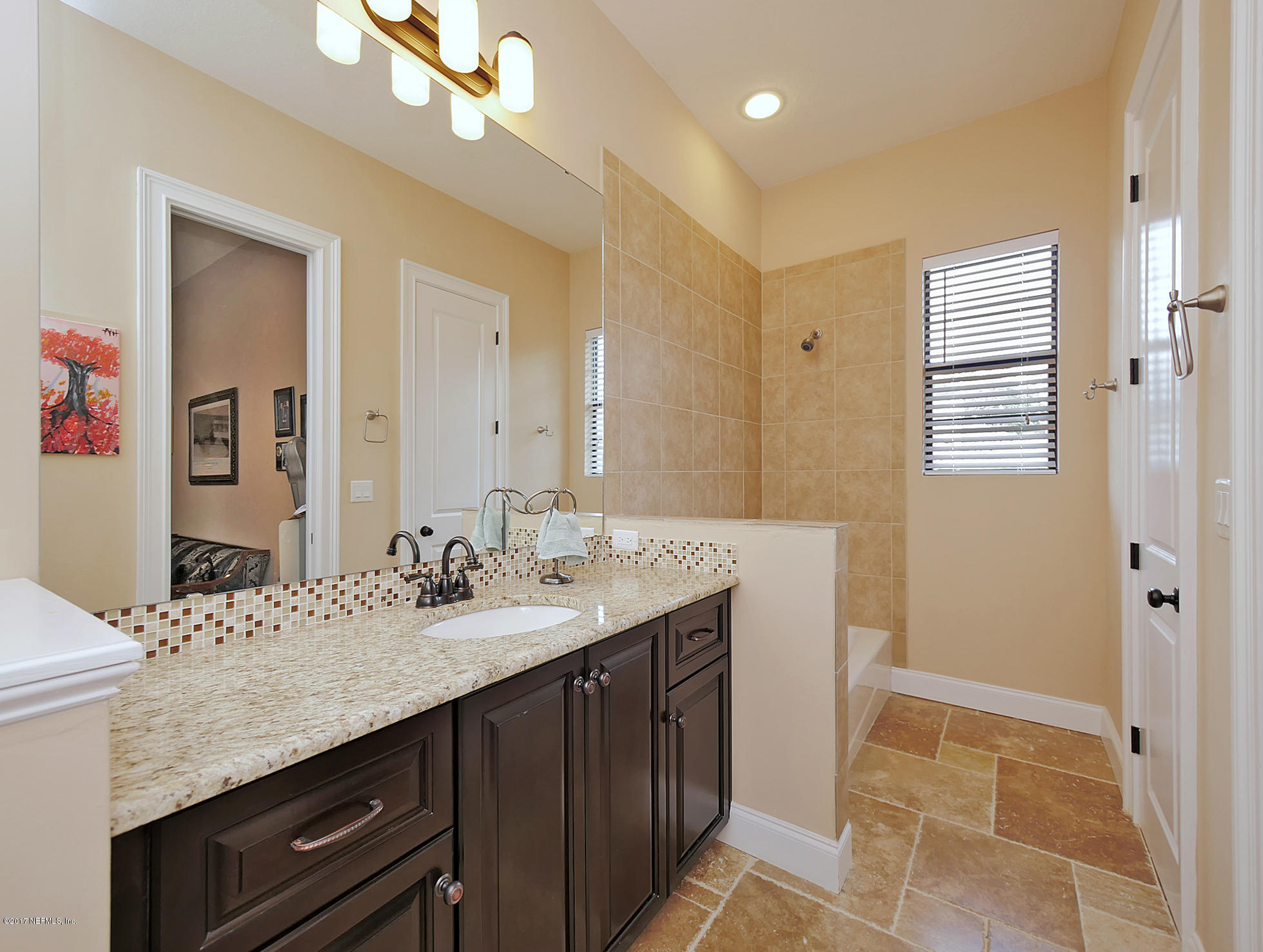 8074 Green Glade Road Jacksonville, FL 32256 - Photo 54 of 71 a bathroom with a granite countertop sink a large mirror and a shower