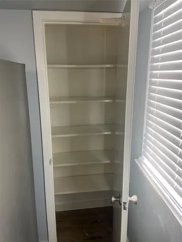a view of walk in closet with empty racks