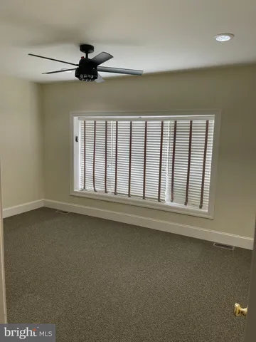 a view of a livingroom with a ceiling fan and window