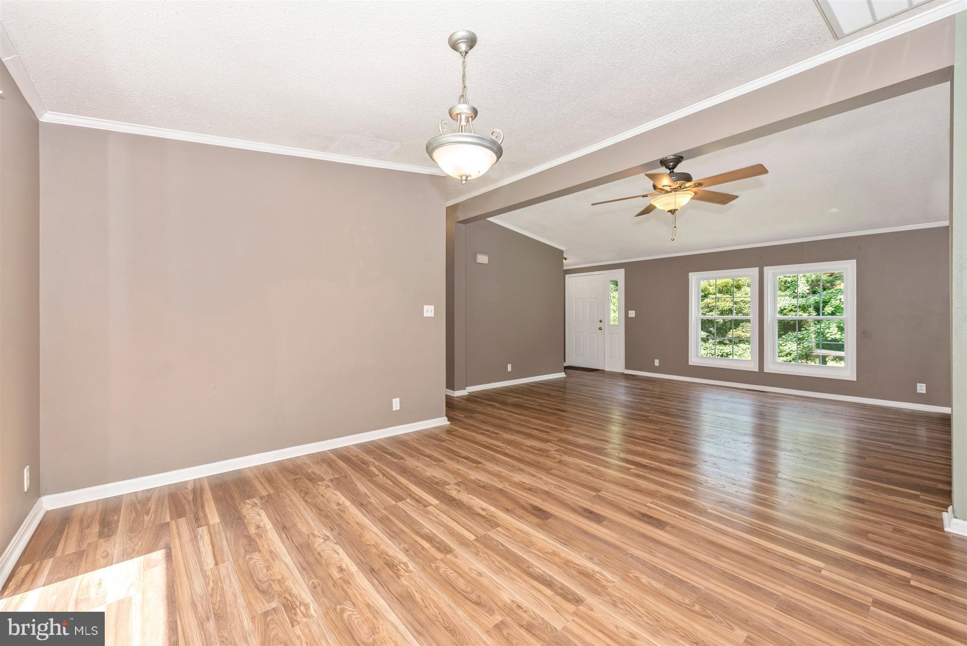 10551 Rum Springs Road Frederick, MD 21702 - Photo 5 of 24 an empty room with wooden floor chandelier fan and windows