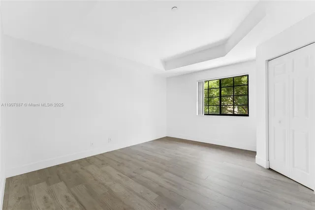 a view of an empty room with wooden floor