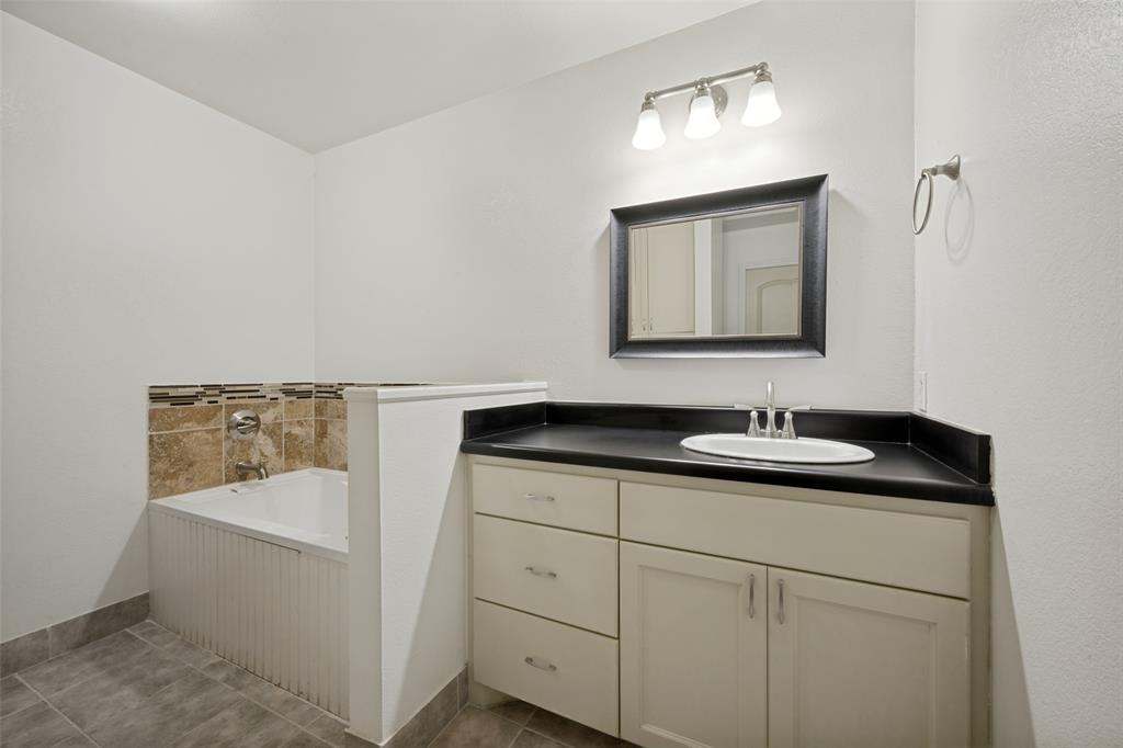 8400 Holder Road Northlake, TX 76247 - Photo 33 of 36 Vanity with integrated sink, dark countertop, and brushed nickel faucet