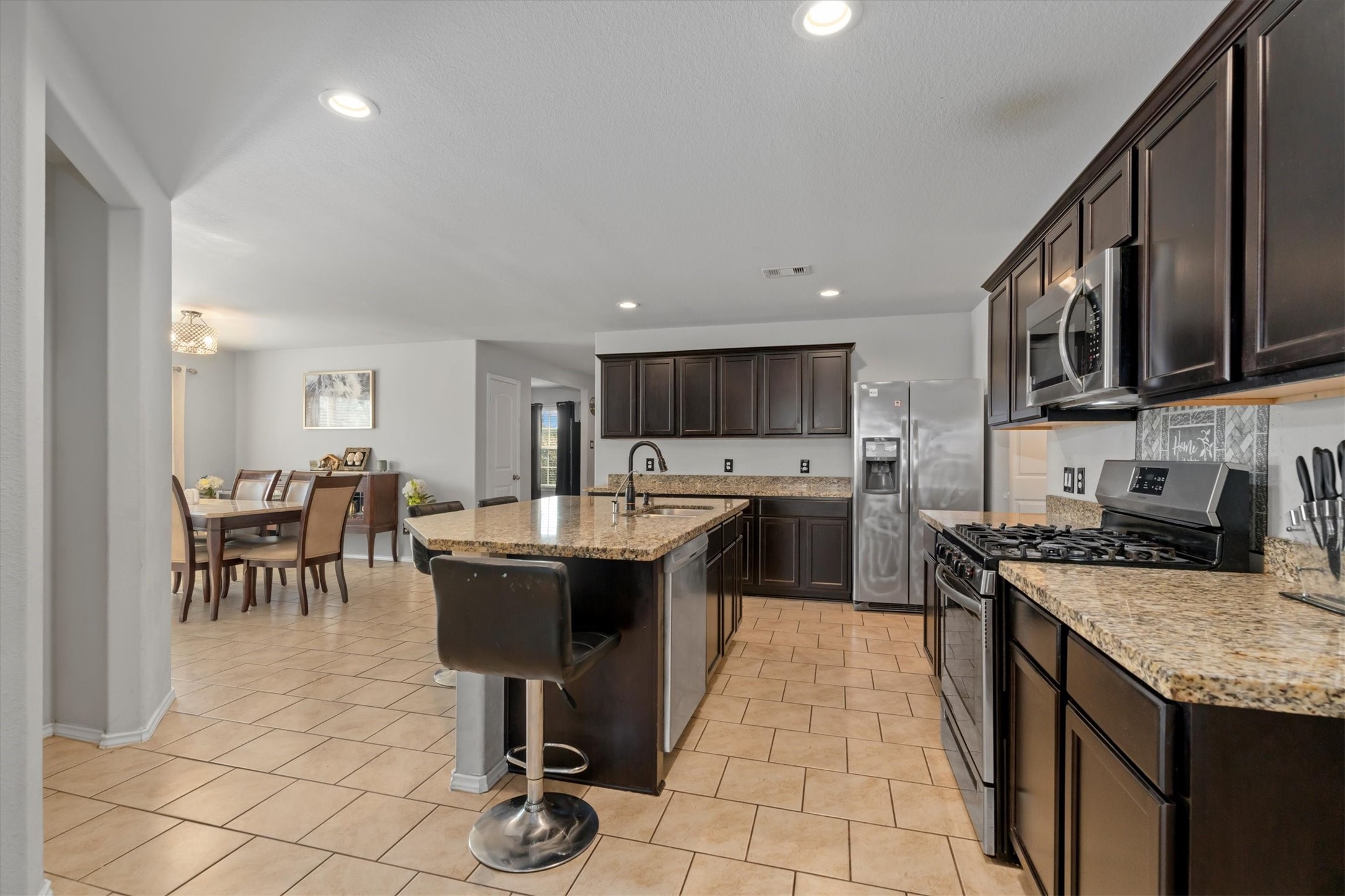 2602 Lincolns Meadow Drive Spring, TX 77373 - Photo 8 of 39 a kitchen with stainless steel appliances granite countertop a sink a stove top oven a dining table and chairs